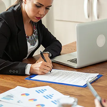 A woman signing a paper about asset protection