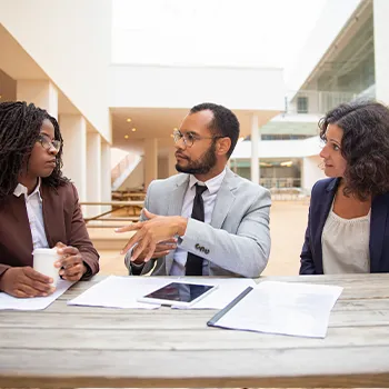 Three people wearing corporate attire having a discussion