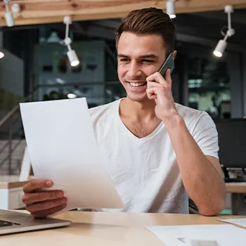 A man smiling while talking to the phone