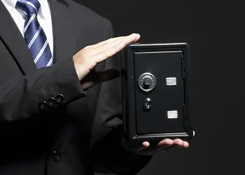 Person in business attire holding a safe