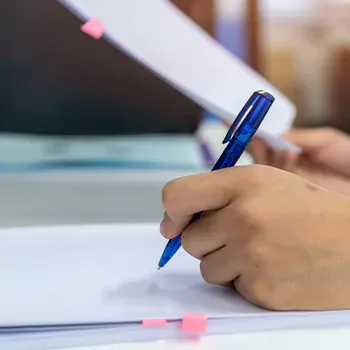 A woman writing down notes in starting a New York LLC