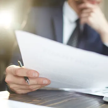 Man thinking and reading a piece of document