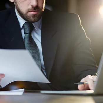 Venture Smarter | What is an LLC Registered Agent? (The Complete Guide) A man organizing paperwork for managing compliance documents