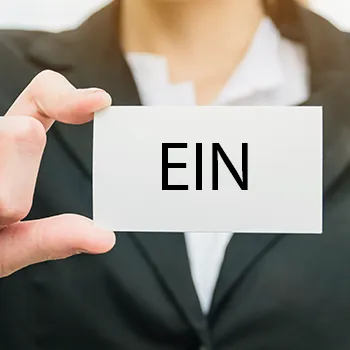 Woman in formal attire holding a plain white card