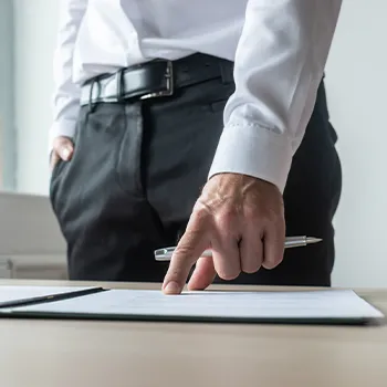 A man in his office pointing at a file