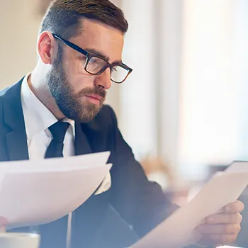 A person in business attire reading through the files