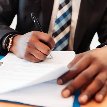 A busy man working in his office and writing his signature on a document