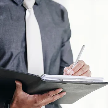 Venture Smarter | What is an LLC Registered Agent? (The Complete Guide) An agent working and writing on a folder full of important documents