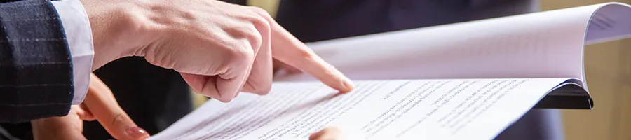 A person in business attire pointing at a document