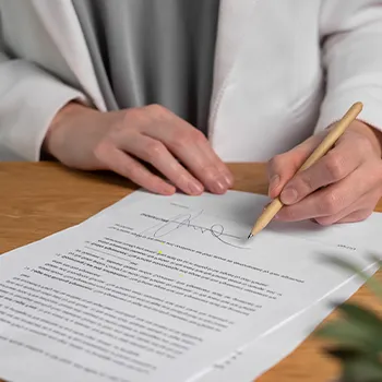 A woman signing a paper for a Rhode Island LLC