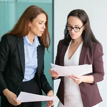 Two coworkers discussing paperwork between each other