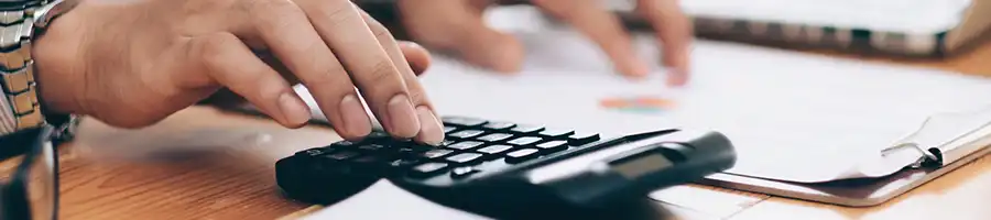 Busy person calculating taxes on table