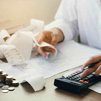 man using a calculator while reading expenses