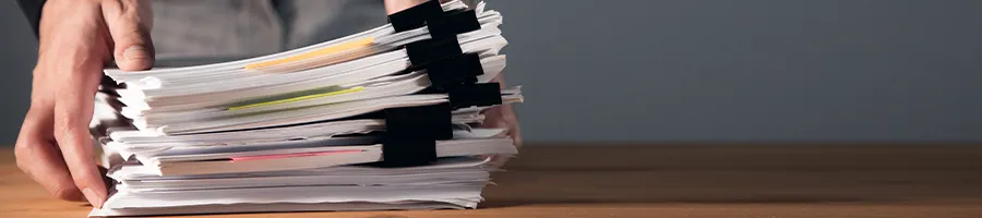 A person laying down a stack of paper documents for an LLC in Ohio