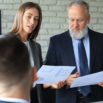 Two co-workers holding files while in a meeting