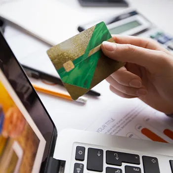 Holding a card while registering on a laptop