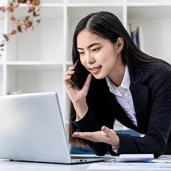 Woman on call while looking at her laptop