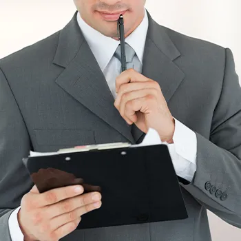 Man thinking while reading documents on clipboard