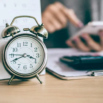 Calendar behind a clock and a person searching what is Delaware due date for LLC taxes