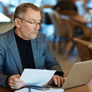 An old aged manager using laptop and focused on work