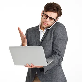 Busy man talking to his phone while working on laptop