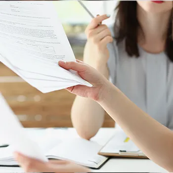 Woman talking to coworker while holding files