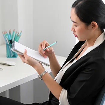 Woman in formal attire writing notes