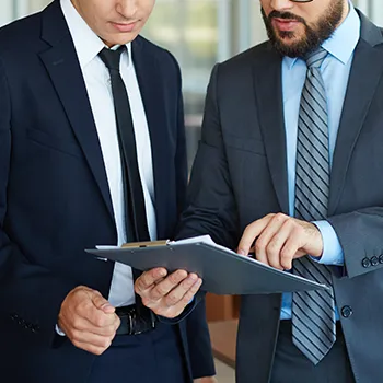 Interaction between two businessmen analyzing a file