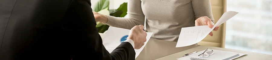 Woman holding a notice paper while talking to coworker