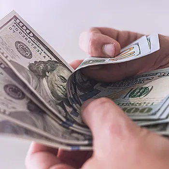 A man counting bills for guaranteed payment