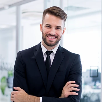 A man in business attire smiling at the camera