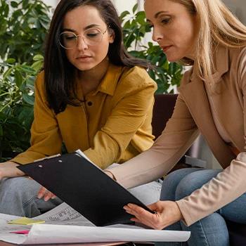 Serious women looking at the document file on clipboard