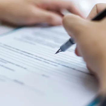 A man signing a paper and wondering what does LLC means after a business name