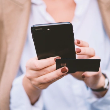 An LLC owner holding a business credit card and a phone