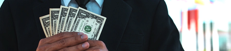 Man in business suit holding an amount of dollar bills