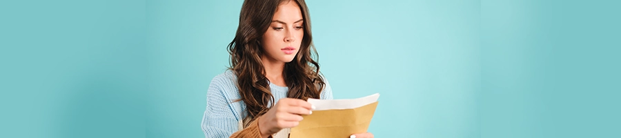 Teenager reading a document from an envelope