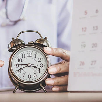 Pointing at clock with a calendar beside