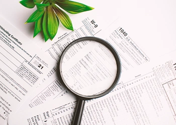 magnifying glass on top of tax forms