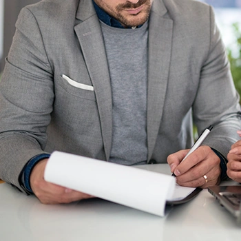 A man busy writing on a document inside a clipboard