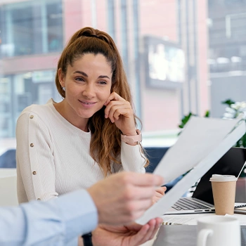 Woman watching her co-worker file and organize articles