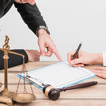 Writing signature on a contract or license and is being pointed at by the lawyer