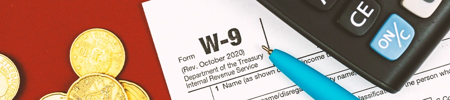 Tax From w-9 top view with calculator and coins