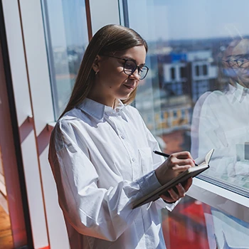 Woman near the window writing notes