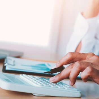 A man using a calculator with a pen in hand