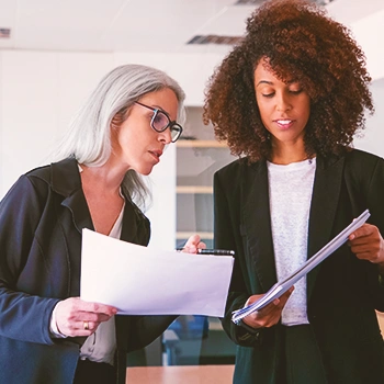 Two women looking at two papers