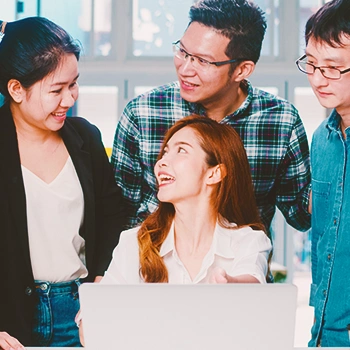 Office members gathered around a laptop having a discussion about what type to choose for a mental health professional