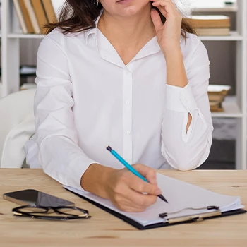 Woman writing on a clipboard document