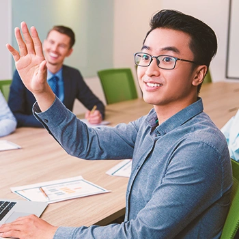 A man raising his hand in an office