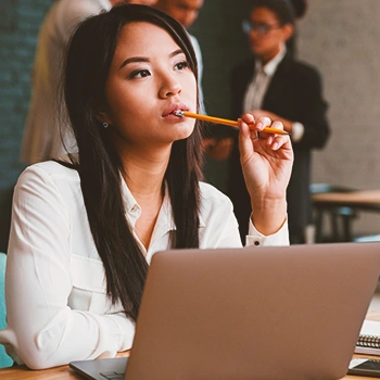 An office worker thinking in front of laptop