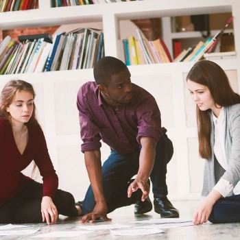 Three colleagues discussing on the floor